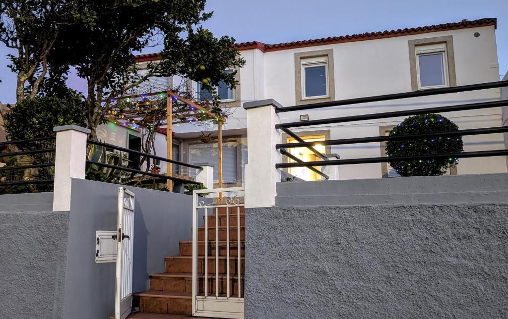 a white house with a gate and stairs at Casa Carmen e do Hilario in Ponte Do Porto