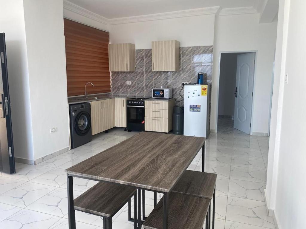 una cucina con un tavolo di legno e un frigorifero di Sigma Theta Homes - Ayi Mensah a Peduasi