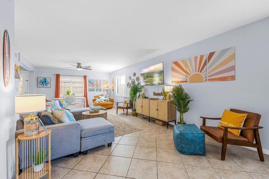 a living room with a blue couch and chairs at Downtown Cocoa Beach Townhome- Walk to Everything in Cocoa Beach