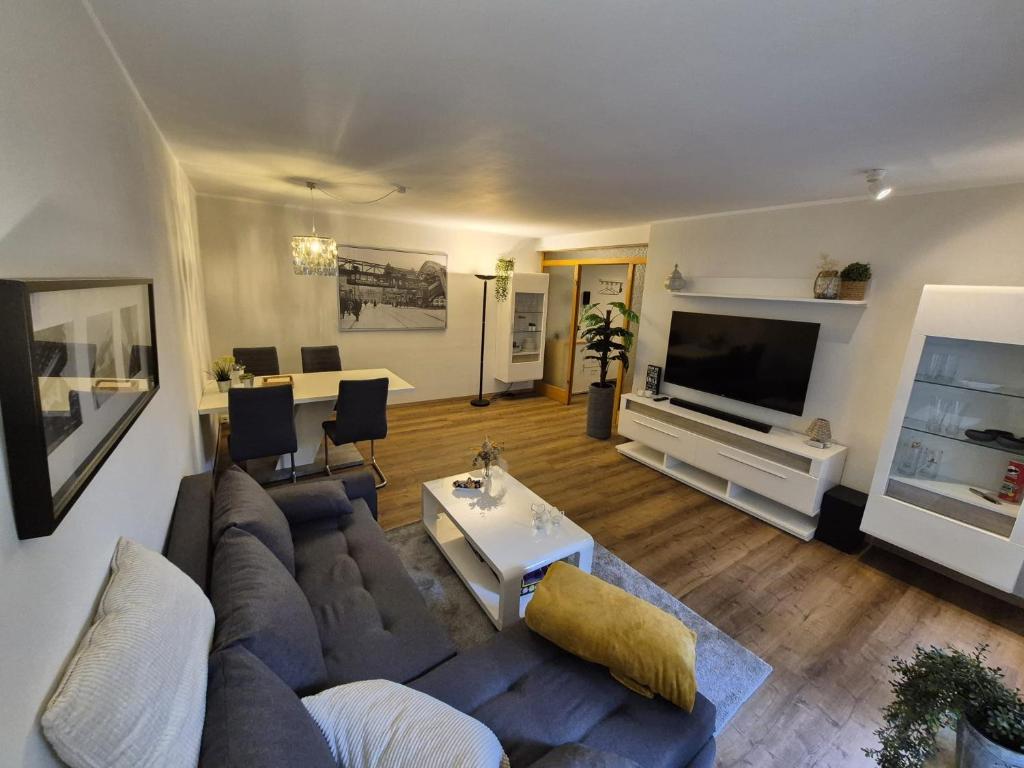 a living room with a couch and a tv at Uni- und Citynahe Souterrain-Wohnung am Waldpark in Wuppertal