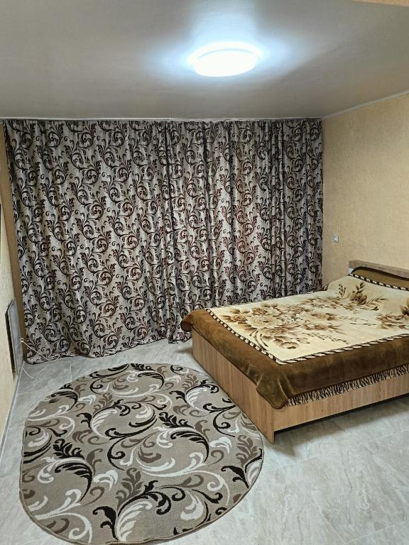 1 комнатные апартаменты في Pavlohrad: غرفة نوم بسريرين وسجادة كبيرة