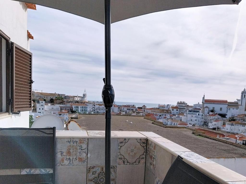 a view of a city from a balcony with an umbrella at Panorama Old Town sea view Albufeira in Albufeira