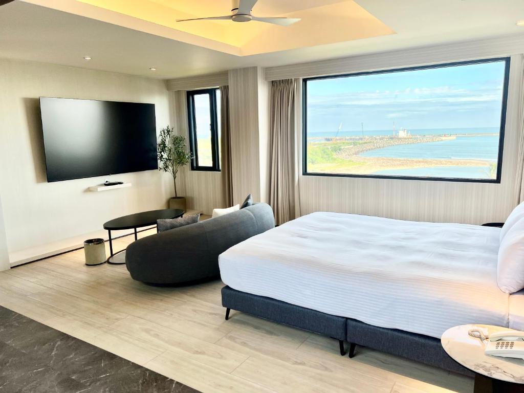 Fair Tale Motel - Sea في مدينة هوالين: غرفة نوم بها سرير كبير وتلفزيون بشاشة مسطحة