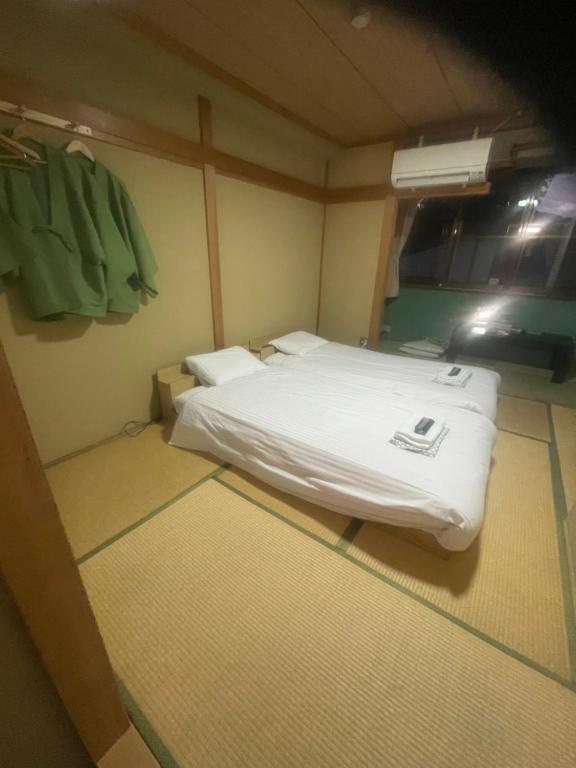 a small bedroom with a white bed and a window at ホテル富士山水館富士山一望河口湖車で3分 in Fujikawaguchiko