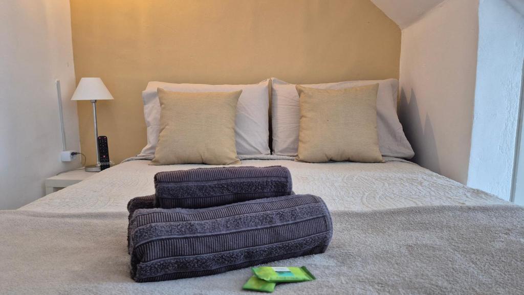 リオデジャネイロにあるLoft aconchegante na praia do Recreioの枕とスリッパが置かれたベッド