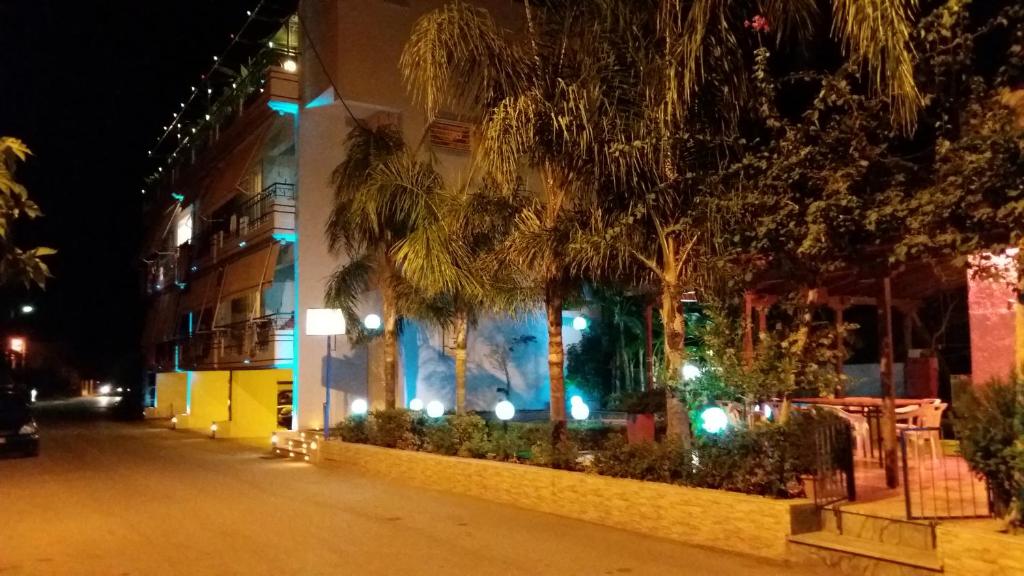 un bâtiment avec des palmiers en face d'une rue dans l'établissement La Fontaine Apartments, à Kandia