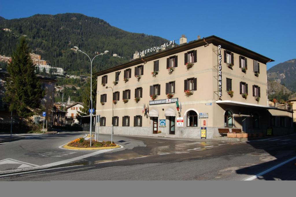 a large white building on the side of a street at Hotel Delle Alpi in Sondalo