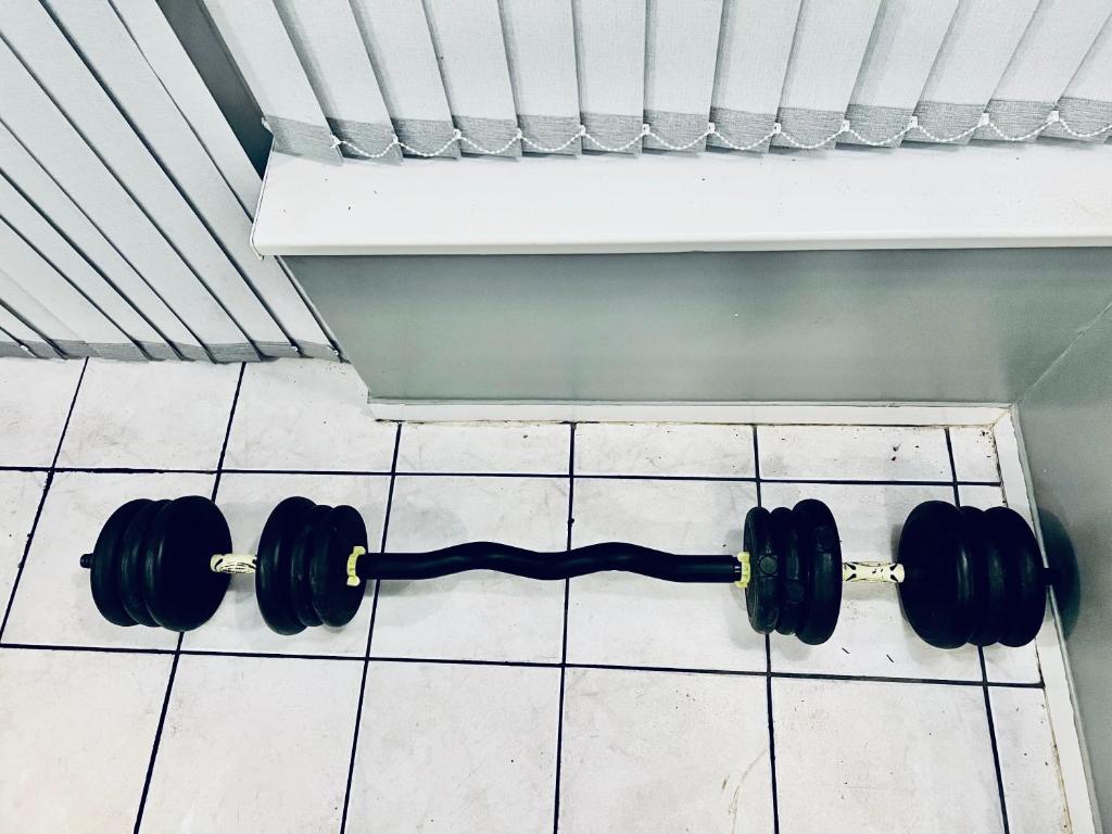 un paio di manubri neri su un pavimento piastrellato di Mona a Hull