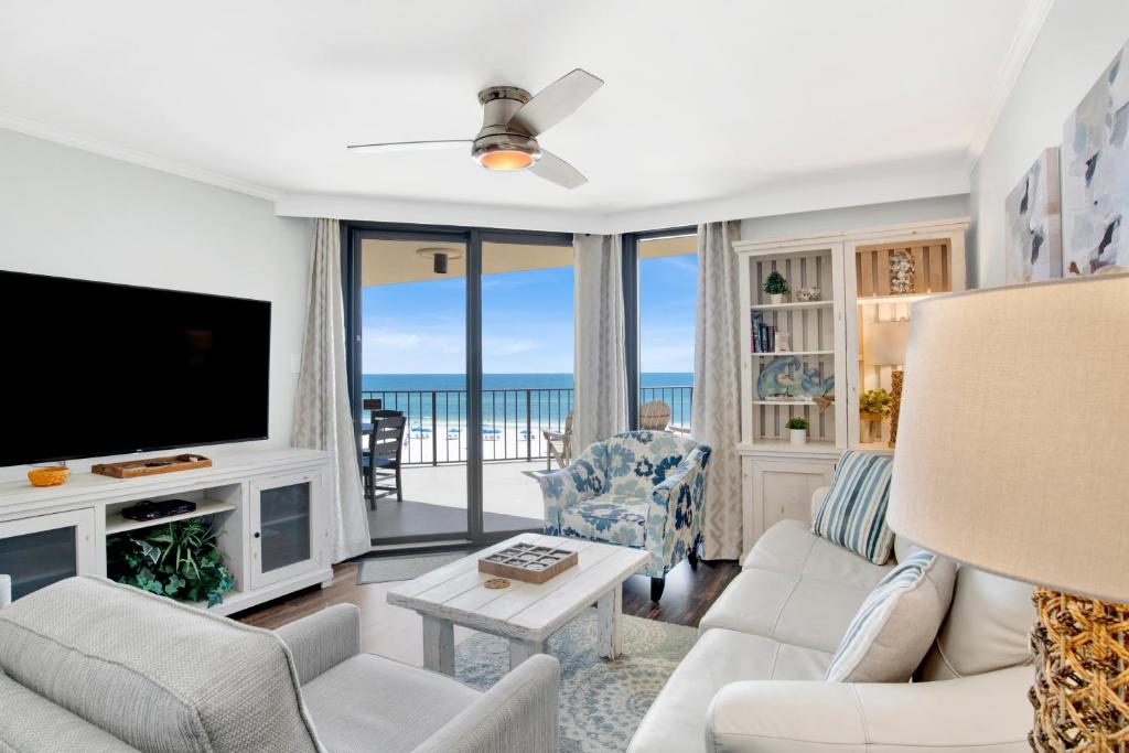 a living room with a television and a couch and chairs at Phoenix III 3038 in Orange Beach