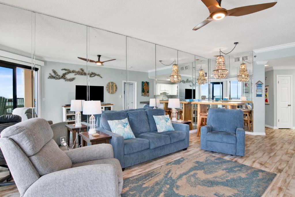 a living room with two blue couches and a kitchen at Phoenix East II 2154 in Orange Beach