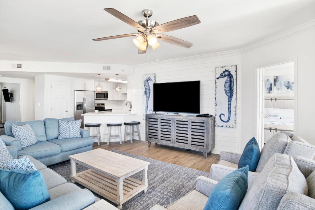 a living room with blue furniture and a flat screen tv at Phoenix X 1201 in Perdido Key