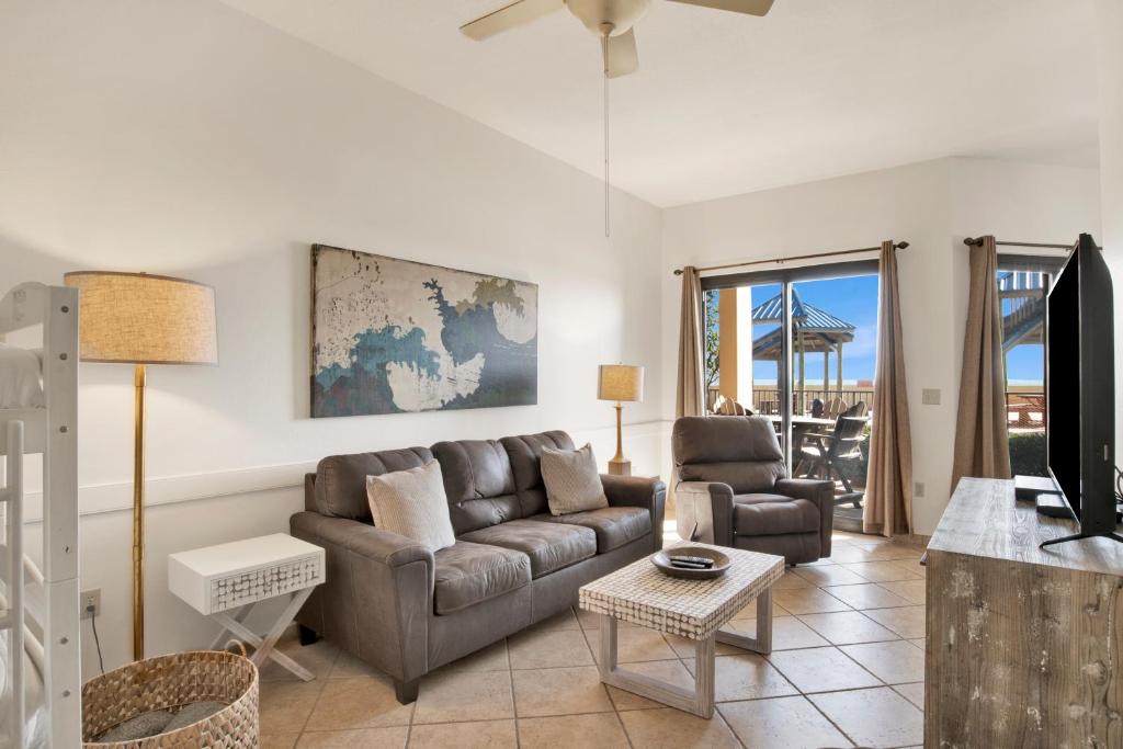 a living room with a couch and a tv at Phoenix V 014 in Orange Beach