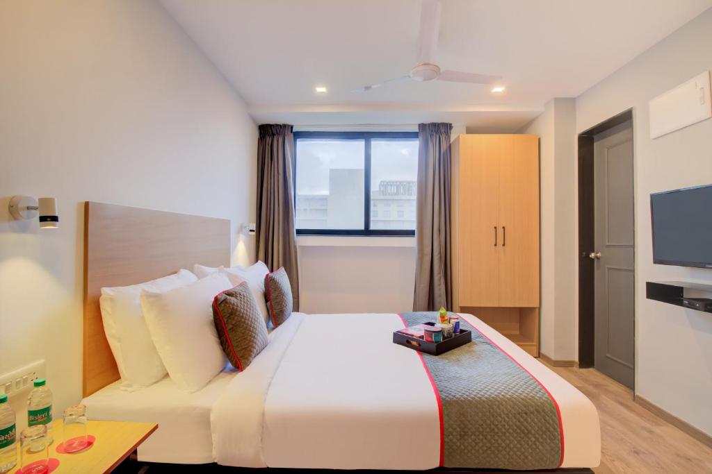 una camera d'albergo con un letto e una tv di Townhouse Alpha a Pune