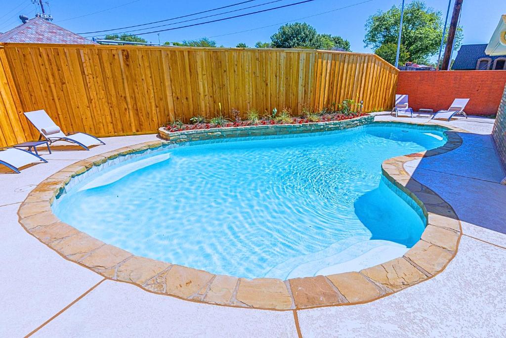 a small swimming pool with chairs and a fence at Plano 40 miles to Fifa Stadium Private Pool Lux Home by Vacation Your Way in Plano