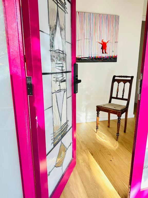 a pink door with a chair in a room at Stylish 2BR Family-Friendly Retreat 4Guests Doncaster Westfield in Doncaster
