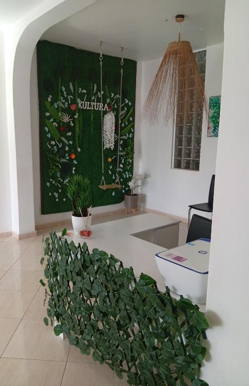 a living room with a green wall with plants at Four Palms Guest House in Praia
