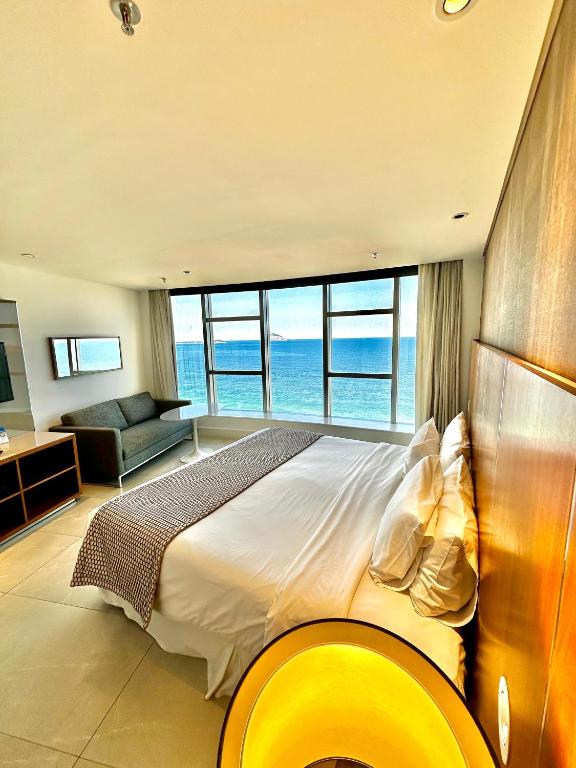a bedroom with a large bed with a view of the ocean at Hotel Nacional in Rio de Janeiro