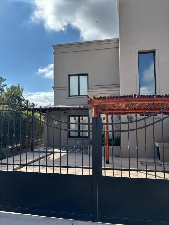 une clôture avec un portail en face d'une maison dans l'établissement Casa Alquiler Amoblada Salta, à Salta