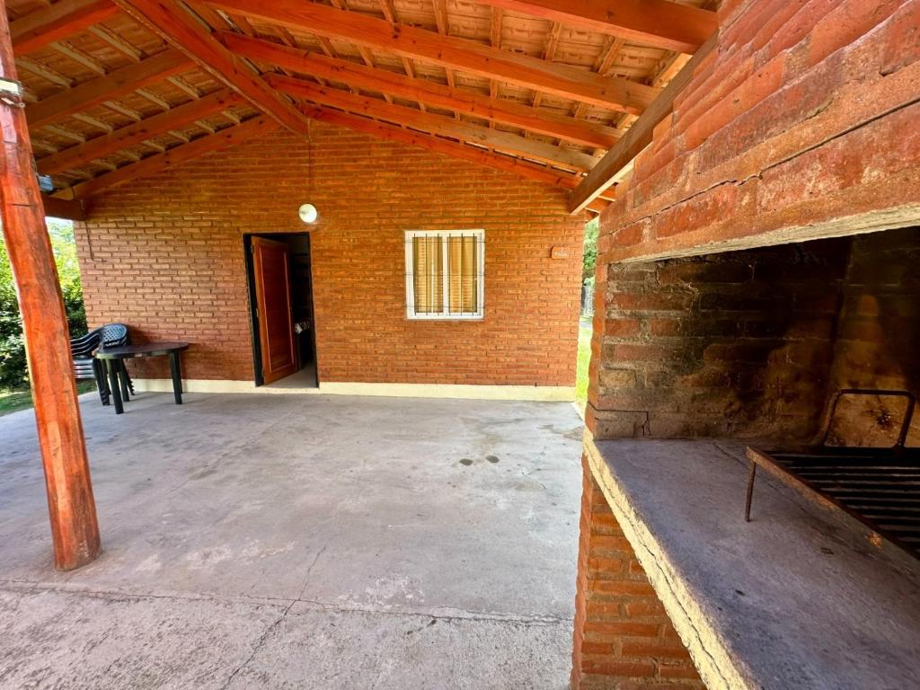 eine Außenterrasse mit einer Ziegelmauer und einem Tisch in der Unterkunft Shanti Cabañas in Mina Clavero