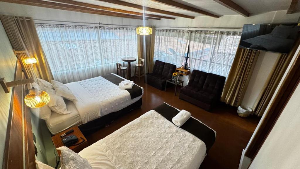 a hotel room with a bed and a couch at Hotel Boutique MIRANDO AL SOL in Ollantaytambo
