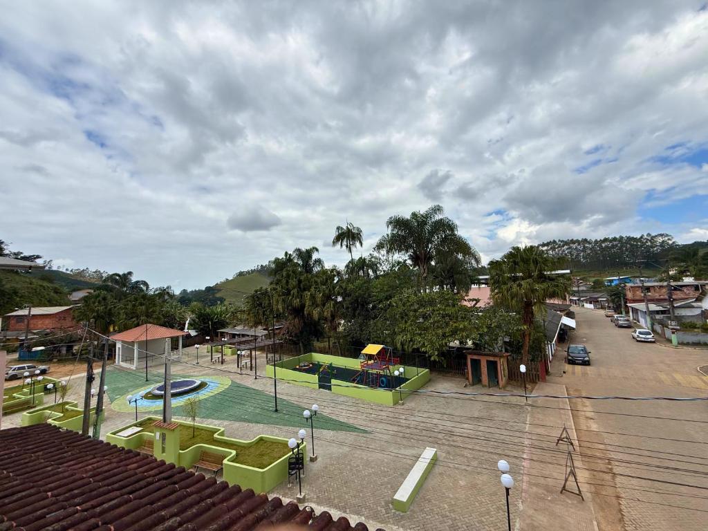 vue d'une aire de jeux avec piscine et parking dans l'établissement Hostel Ninho das Harpias, à Divino de São Lourenço