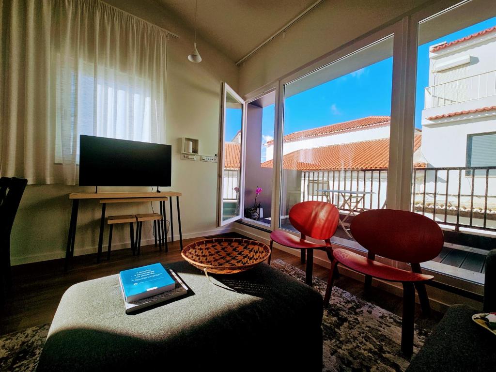 ein Wohnzimmer mit Sofa und Fernseher in der Unterkunft Apartamento Sonho Sky in Ponta Delgada
