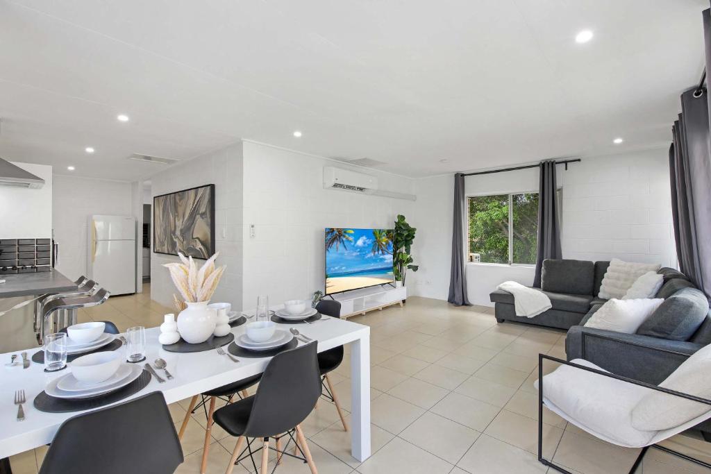 The Coastal Escape - Games & Vibes في غولد كوست: مطبخ وغرفة معيشة مع طاولة وكراسي