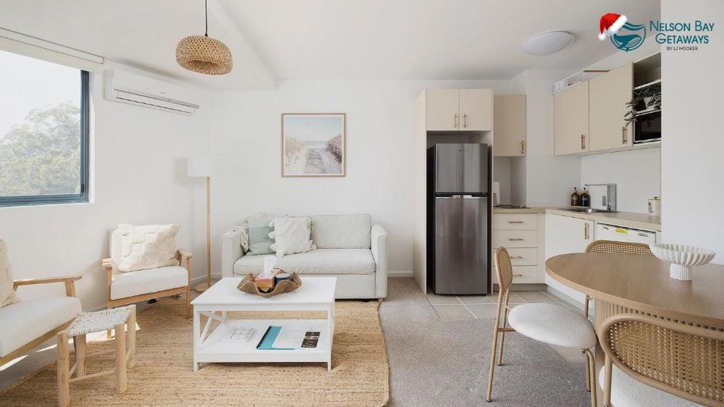 Una cocina y una sala de estar con un sofá y una mesa. en The Landmark- Top Level, en Nelson Bay