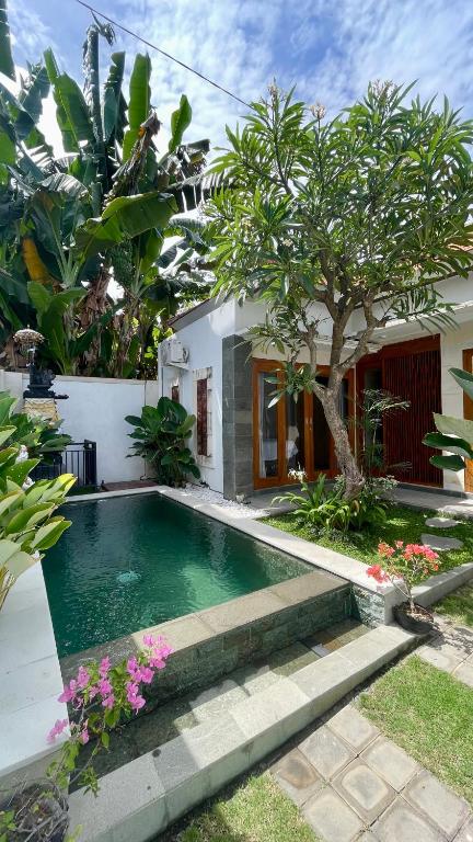 a swimming pool in front of a house at Peaceful Tropical Villa with private pool in Panji