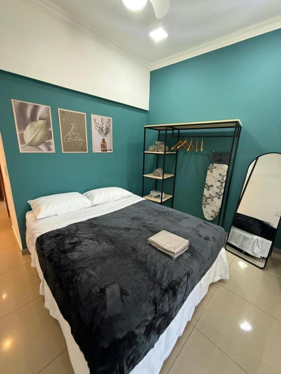 ein Schlafzimmer mit einem großen Bett und einer blauen Wand in der Unterkunft Studio lindo e completo no Centro RJ in Rio de Janeiro