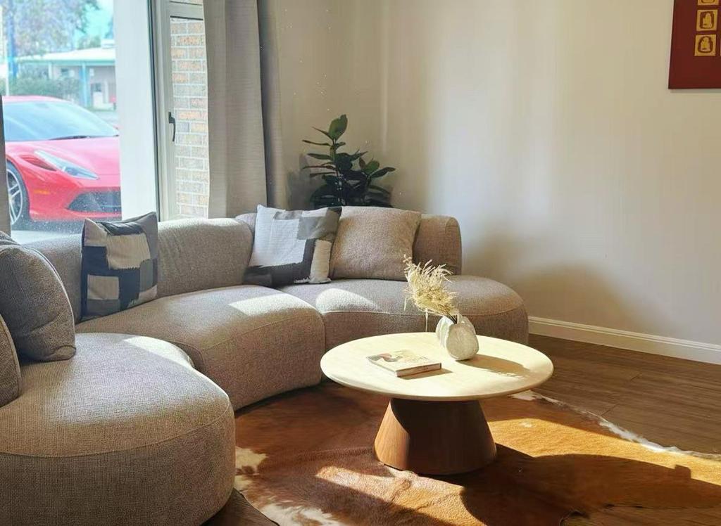 ein Wohnzimmer mit Sofa und Tisch in der Unterkunft Hampton Luxe Retreat 4BR Pet Friendly in Melbourne