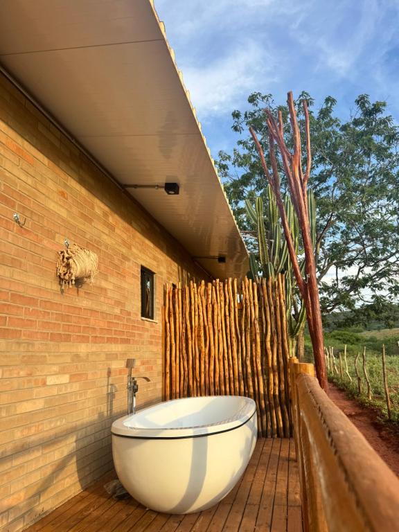 a bath tub sitting on a patio with a fence at Sertão do Luar in Jurubeba