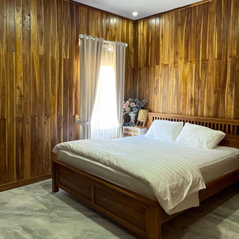 a bedroom with a bed with wooden walls and a window at Villa Bella Sembalun in Sembalun Lawang