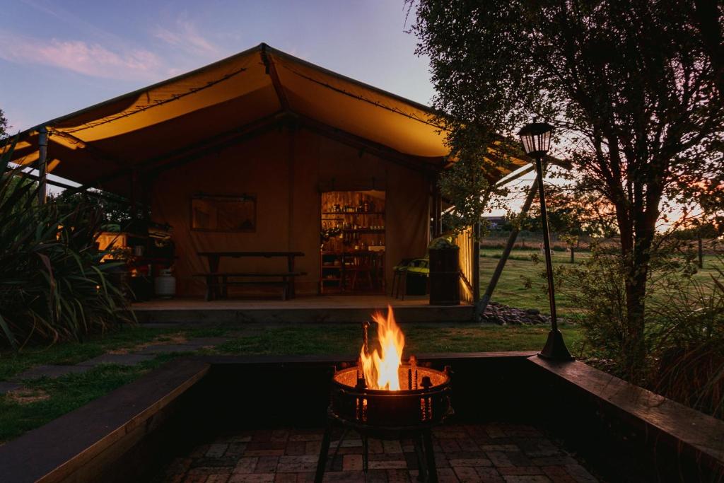 una hoguera frente a una tienda en Raglan Rural Retreats - Rimu Tent, en Raglan