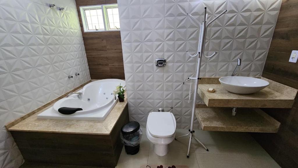 a bathroom with a sink and a toilet at Pousada da Lua Barretos in Barretos