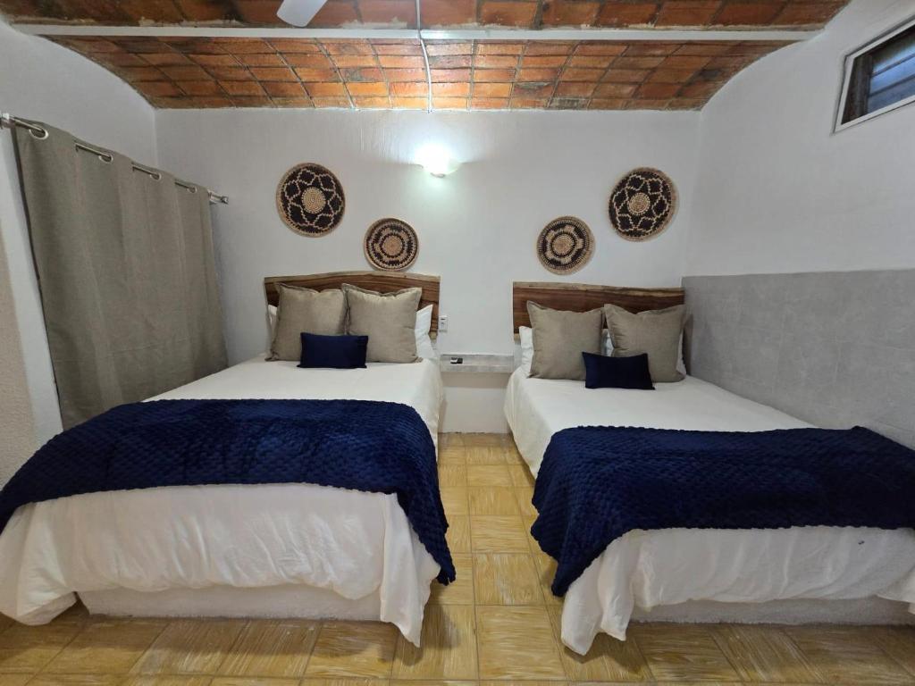 een slaapkamer met 2 bedden met blauwe en witte lakens bij Tayau Bungalows B3 in Lo de Marcos