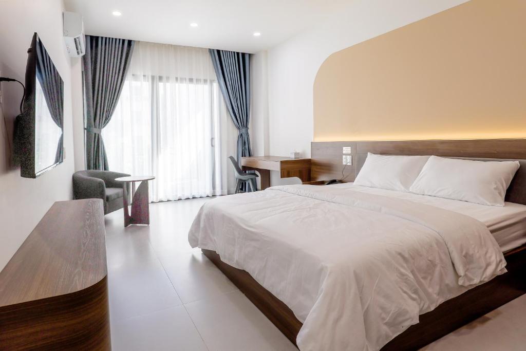 a bedroom with a large bed and a desk at Lumia Hotel in Ho Chi Minh City