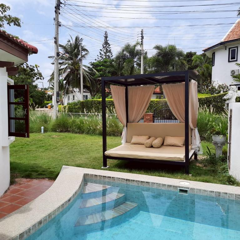 a bed in a gazebo next to a pool at Mi Casa Pool Villa Hua Hin in Hua Hin