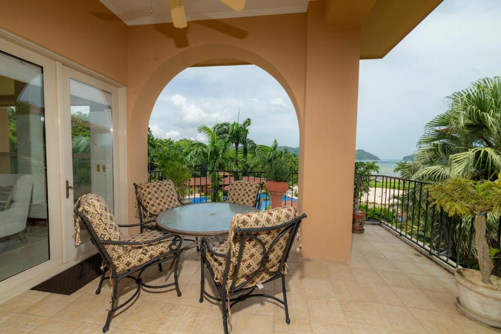 Un patio con una mesa y sillas en un balcón. en Bella Vista 3A 3BR Ocean View, en Isla Herradura