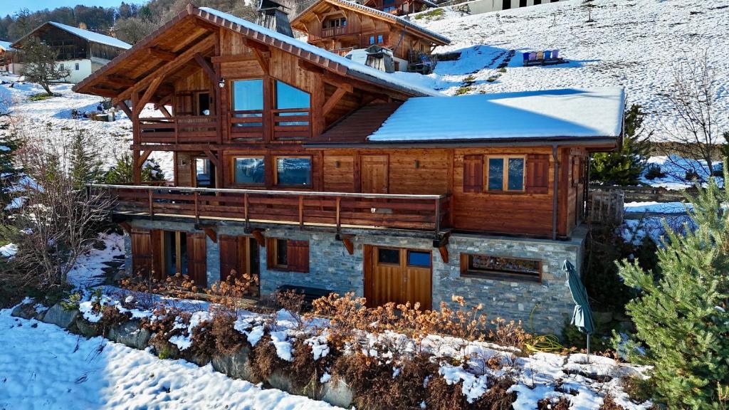 una baita di tronchi nella neve con neve di Chalet face au Mont-blanc a Sallanches