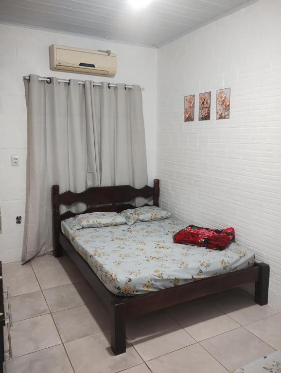 una camera da letto con un letto con una borsa rossa sopra di Pousada Fruteira do Heraldo a São Gabriel