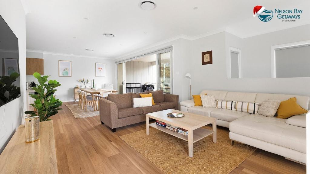 a living room with a couch and a table at Comfort Luxury and Surrounded by Popular Beaches in Boat Harbour