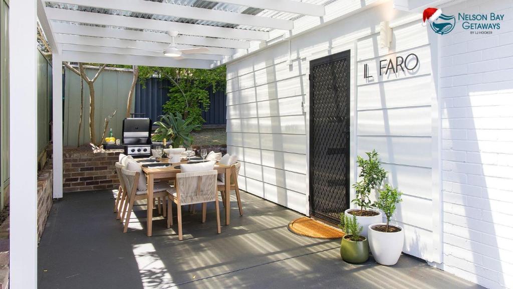 un patio con un tavolo e un computer sopra di Il Faro, An Italian Inspired Villa in Port Stephens a Corlette