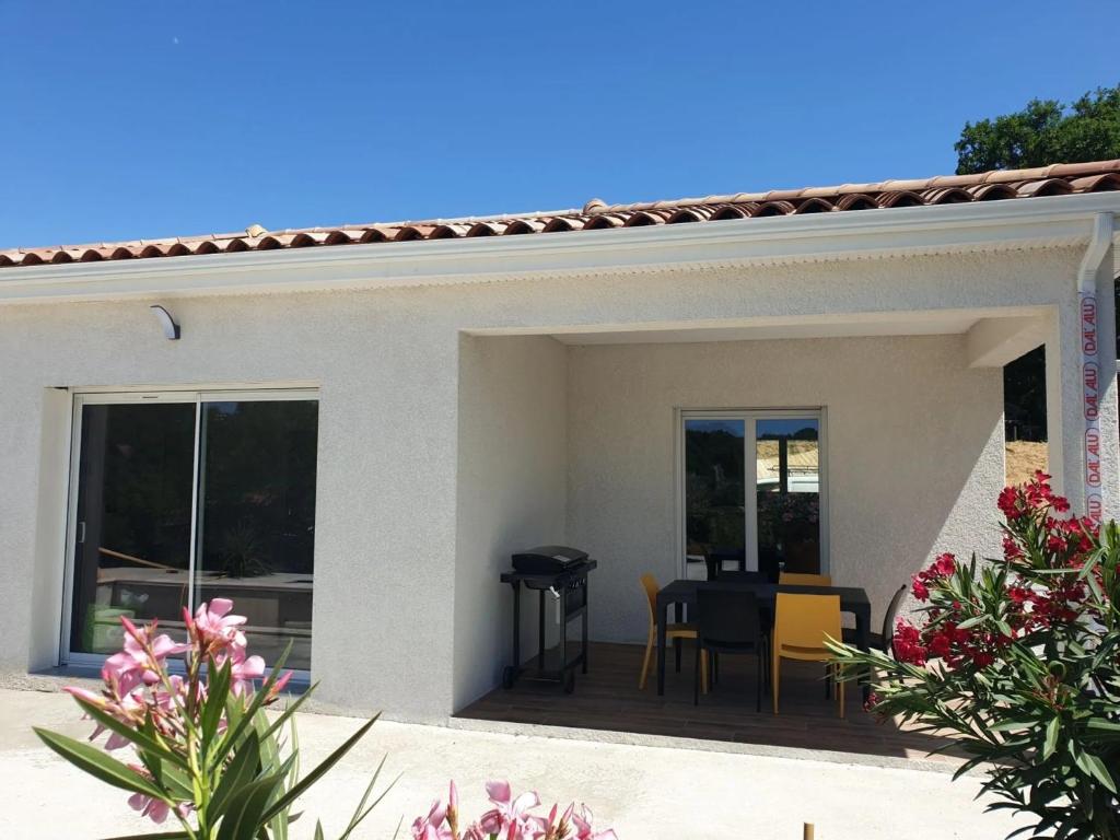 een patio met een tafel en een eetkamer bij Villa Flora in Balazuc