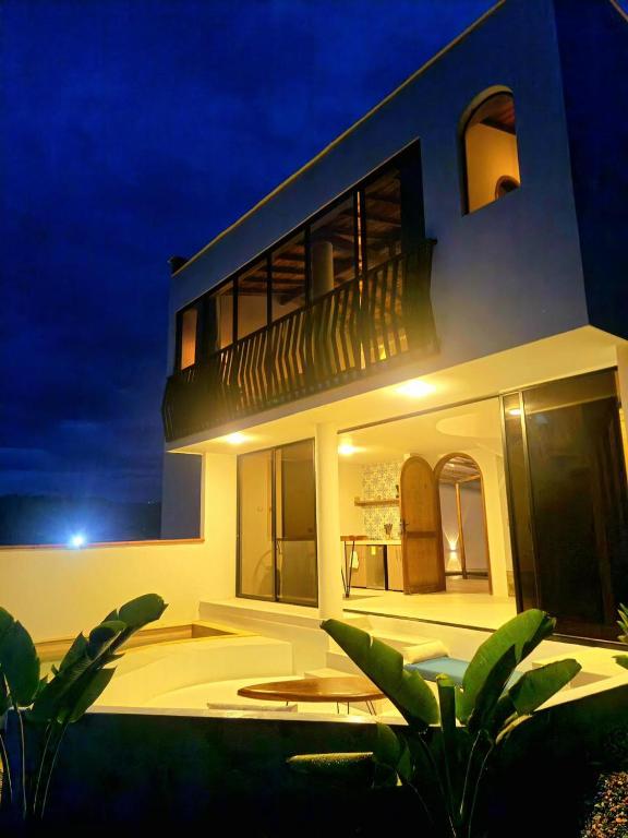 a large white house with a balcony at night at Majestic View House in Curití