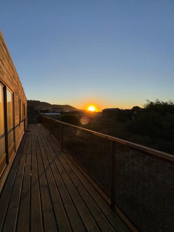 a sunset on the deck of a building at Cabañas Mc Chelo in Pelluhue