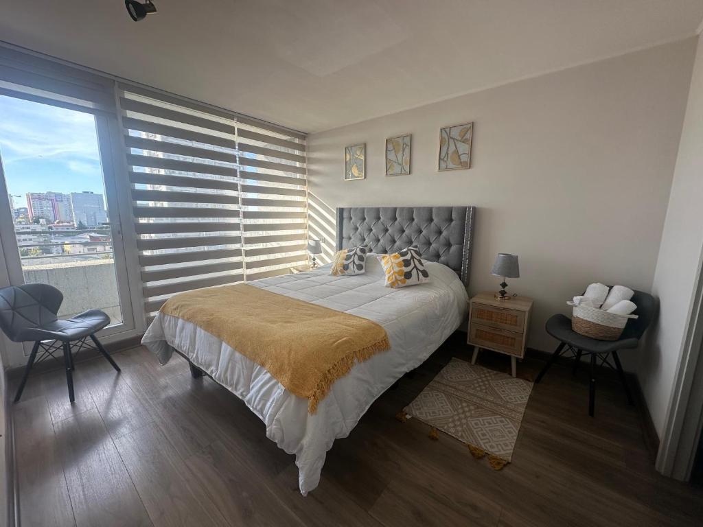 a bedroom with a large bed and a large window at Galardon AyC in Concepción