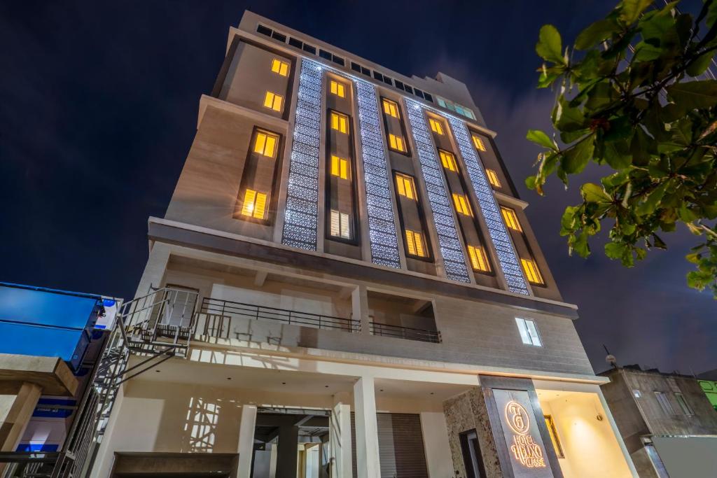 a tall building with yellow lights on it at Hotel Helixo Classic Kompally in Hyderabad