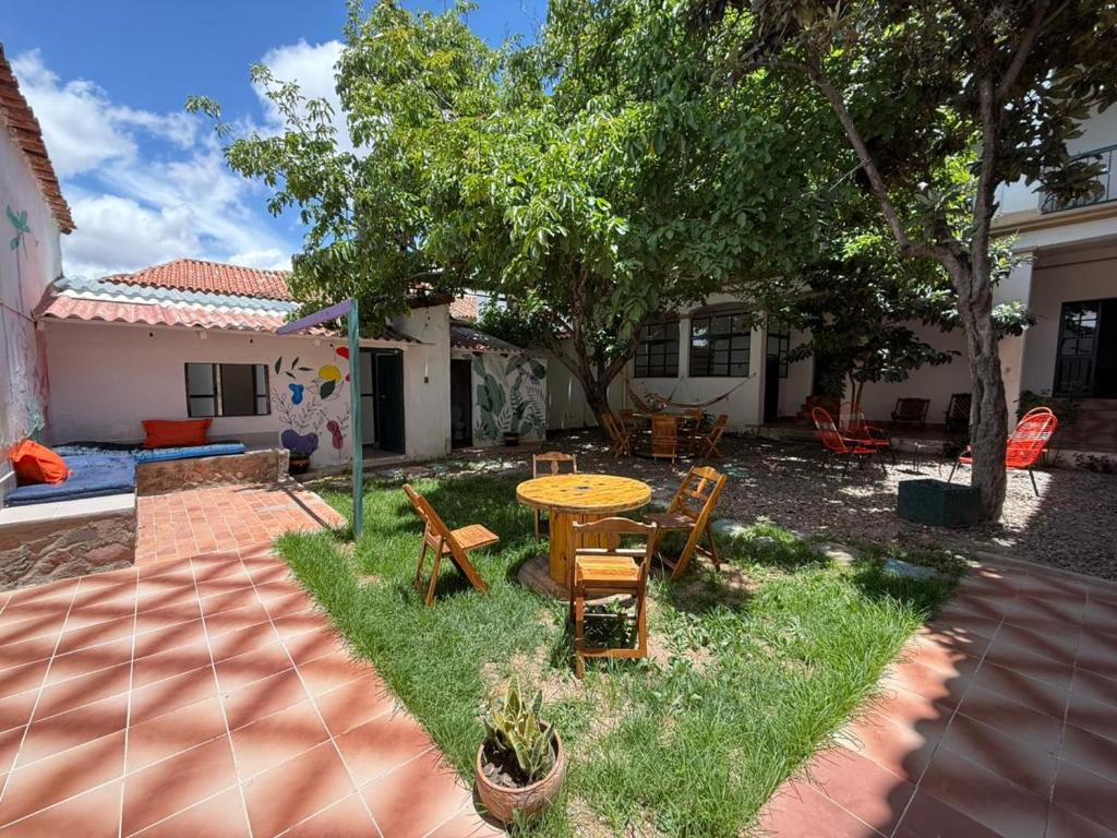 een terras met een tafel en stoelen in een tuin bij Old House Hostel in Sucre