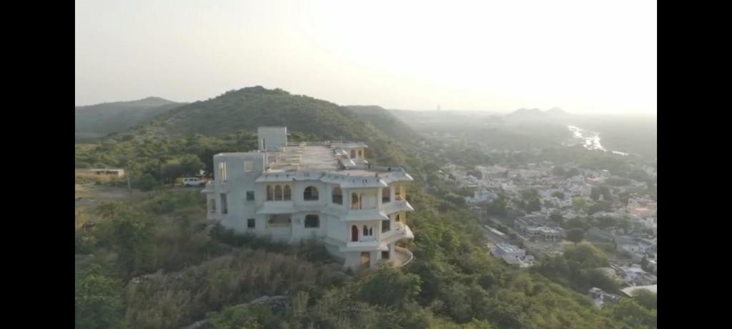 una gran casa blanca en la cima de una montaña en GOVIND GARH NATHDWARa, en Nathdwara